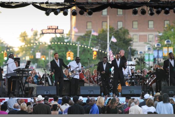 A band on the stage playing in downtown Flint in front of a packed crowd during Back to the Bricks.