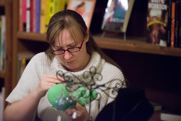 A woman works on a craft project in a bookstore.