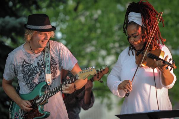 Two performers, a guitarist and a violinist, perform at the Flint Jazz Festival.