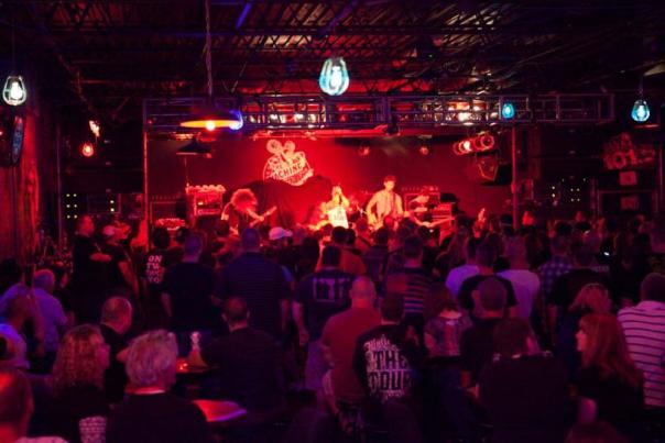 A band plays a set on the stage of the Machine Shop as the crowd sings along.