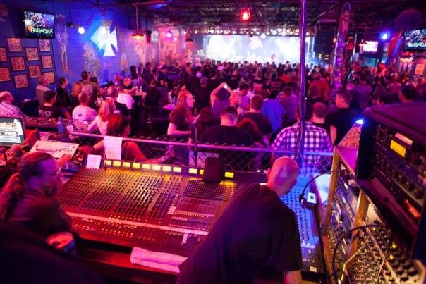 An image from behind the sound board of a crowded Machine Shop as a band plays live.