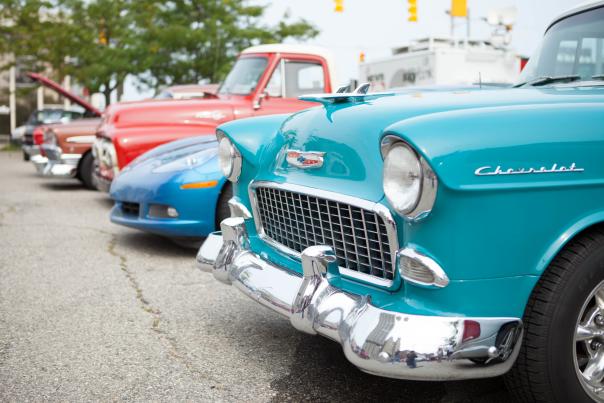 A close-up photo of classic cars on display on the street.
