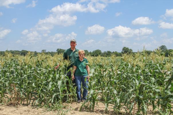 Mother Betty and son Kelly Walker Pose in their corn field at Walker Farms on a sunny day.