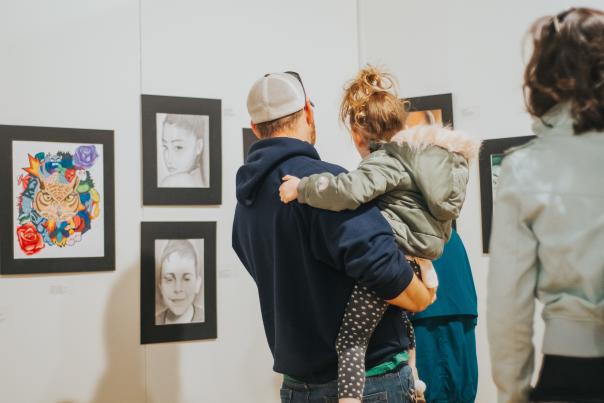 A father and daugther at the Greater Flint Arts Council looking at art.