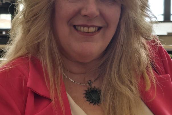 A photo of Tracy Tucker, sitting in the Flint & Genesee Group offices.