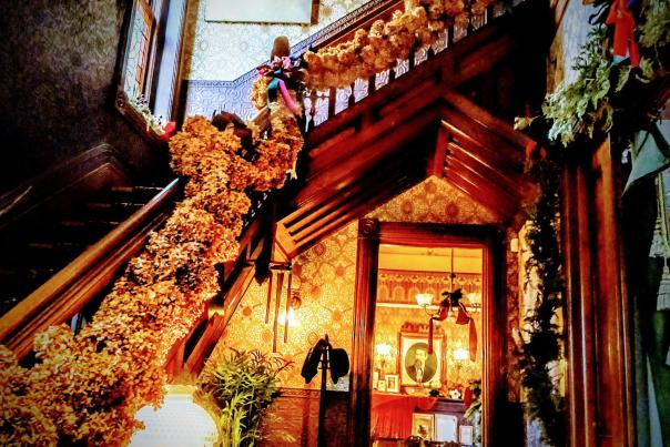 An image of the Grand Staircase at Whaley Historic House Museum decorated for an 18th Century Christmas.