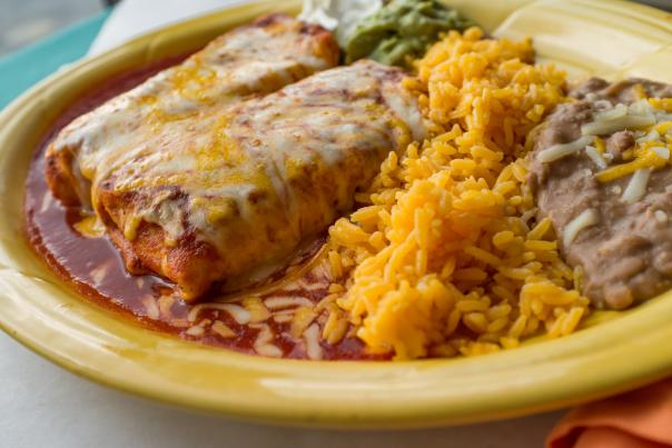Mexican cuisine (burritos, rice, and beans) sits on a yellow plate.
