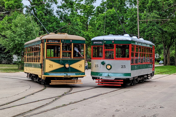 two trolley cars next to each other on the tracks