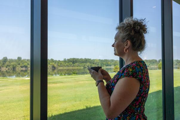 A woman sips coffee and looks out at the Arkansas River from the Fort Smith Coffee Company.