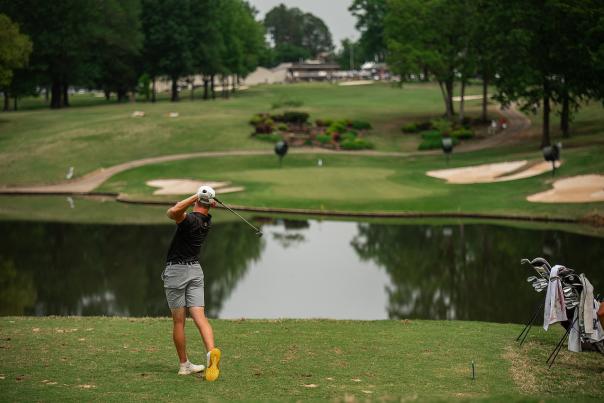 A man putts a golf ball over a pond at Hard Scrabble Country Club in Fort Smith, AR.