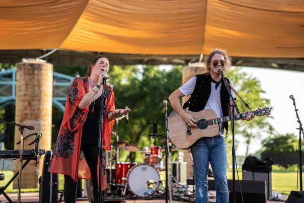 A man plays the guitar while a woman sings on a sunny evening at the Levitt AMP in Fort Smith, Arkansas.