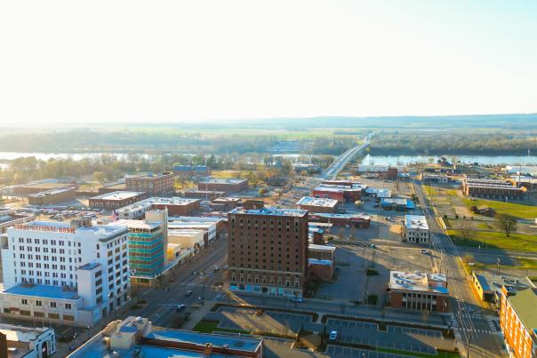 The sun peeks over the Arkansas River and bathes downtown Fort Smith in summer rays.