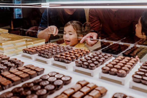 Little girls picking out chocolate at DeBrand Fine Chocolates