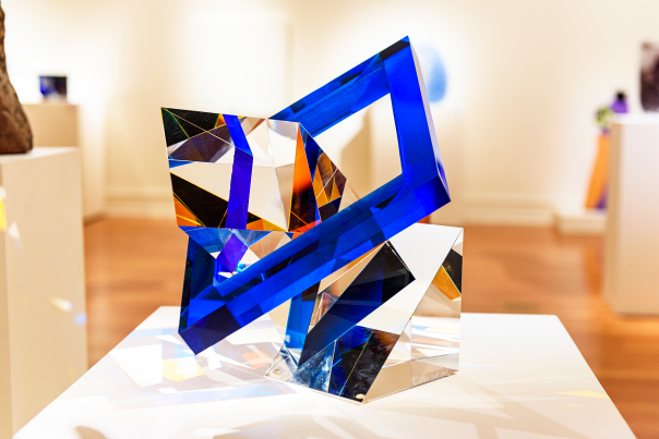 glass sculpture with a blue square outer ring and transparent geometric shapes inside