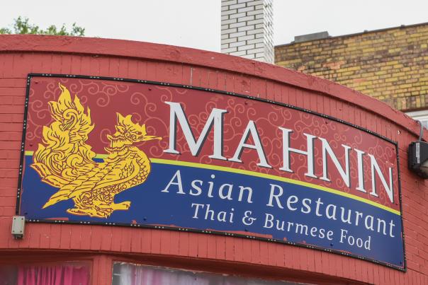 "Mahnin Asian Restaurant Thai & Burmese Food" is written on the storefront of a red brick building