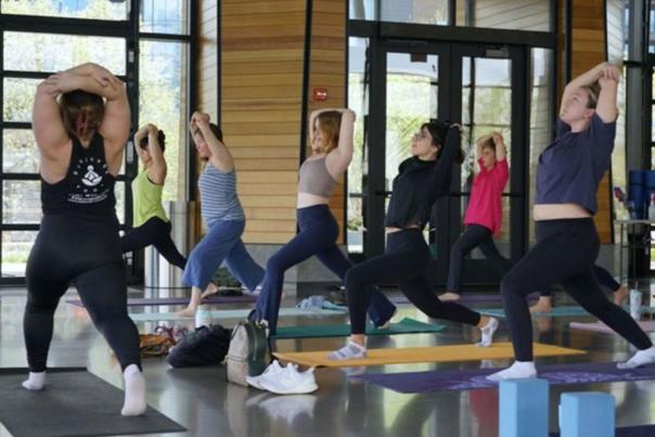 A group of women doing yoga indoors along the river front