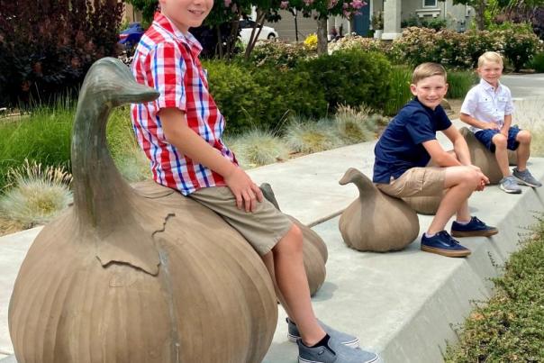 Garlic bulbs on Monterey St. with three boys sitting on them