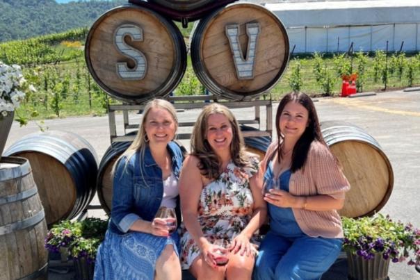 Sarah's Vineyard 3 ladies on bench with barrels