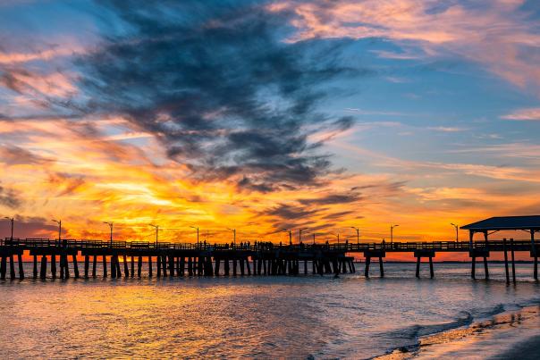 The sun sets behind the St. Simons Island Fishing Pier, a popular attraction on St. Simons Island, GA