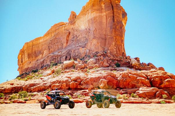 Two ATVs parked in front of Moab’s towering red rocks.