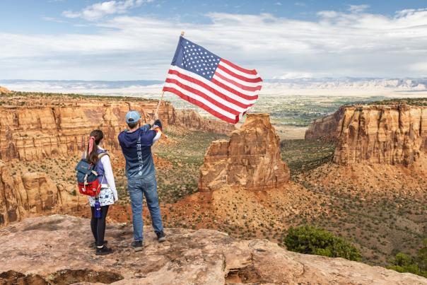 Two People Waving an American Flag on Colorado National Monument