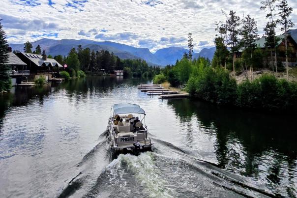 Boat passing through the channel between Shadow Mountain Reservoir and Grand Lake with Mount Craig in the background