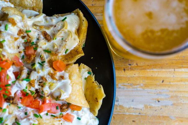 A plate of Brewery Vivant's duck nachos and a pint of beer.