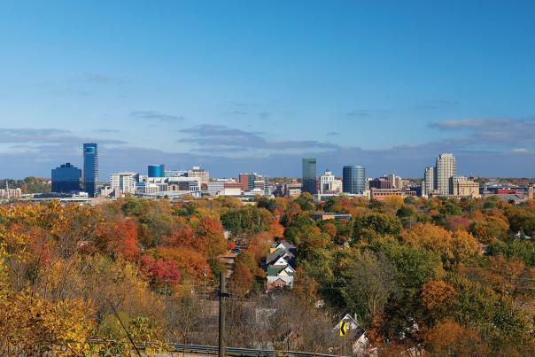 Trees turning fall colors with the Grand Rapids skyline in the background
