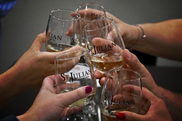 Glasses clinking at St. Julian Winery during Raise a Glass Wine Tour