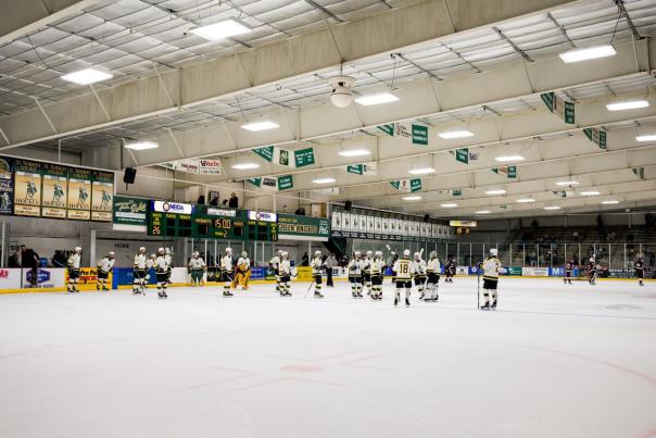 Cornerstone Ice Arena with St. Norbert College hockey players lined up standing at the center of the ice sheet.