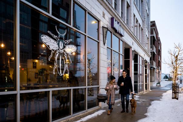 couple walking dog outside the Daily Buzz