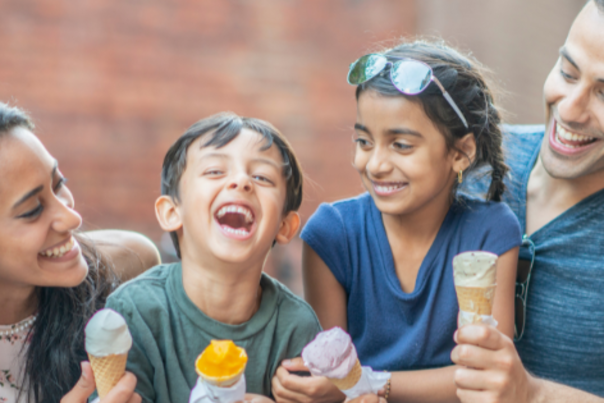 Family of Four Sitting Down Laughing Holding Ice Cream