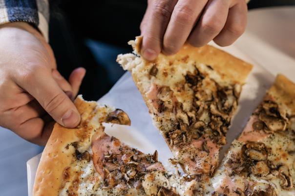 Person pulling a slice of pizza