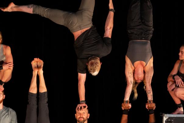 10,000 hours gymnasts do handstands and headstands in front of black background