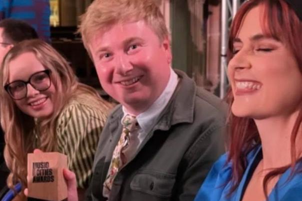 Members from gig buddies hold up their local impact award in Hull Minster