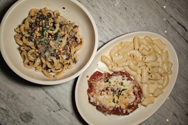 Two white plates with pasta on a gray table top at North Italia restaurant in Huntsville