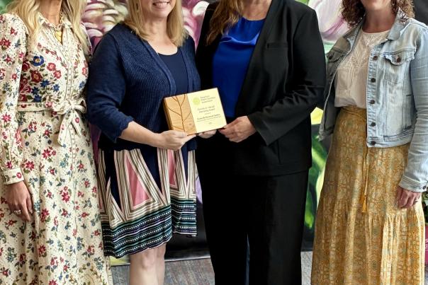 four women representing Huntsville Botanical Garden and Red Sage Communications with two of them holding an award