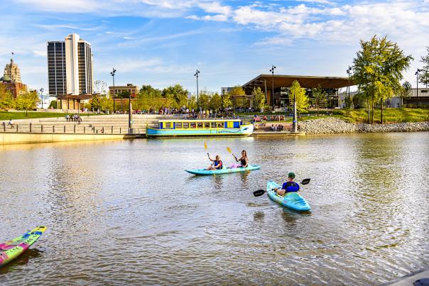 people on kayaks on the river in downtown fort wayne