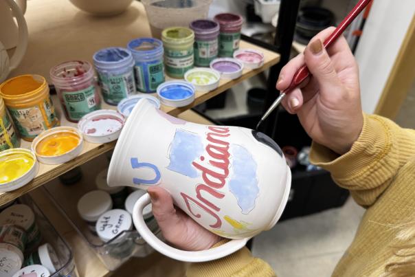 Courtney paints custom mugs