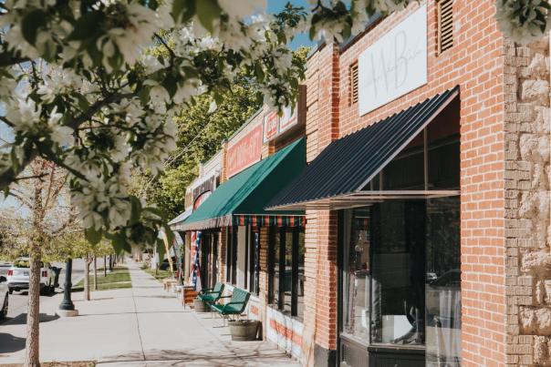 Charming downtown Cedar City street with local shops, brick storefronts, and blooming trees along the sidewalk