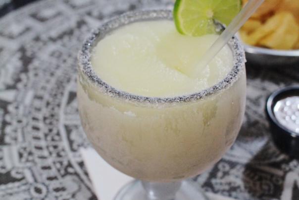A blended classic margarita from Arturo's is served with a salted rim and a slice of lime.