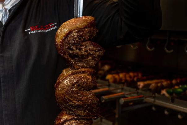 Grilled meat on a sword at Blaze Brazilian Steakhouse in Irving, TX