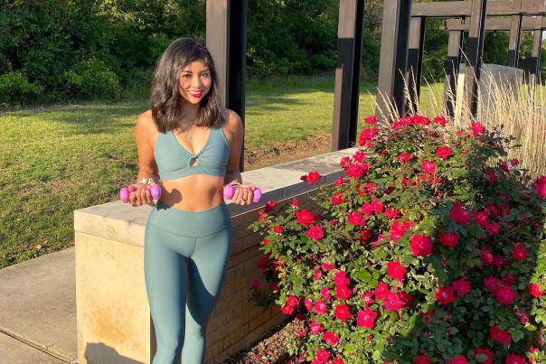 Woman Holding Weights By A Garden In Irving, TX