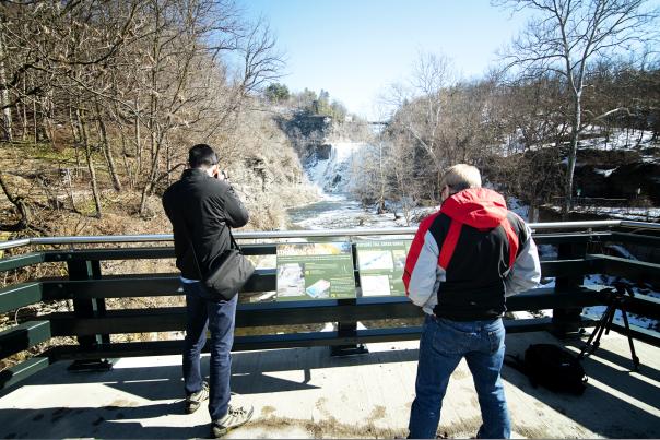 two people at info sign viewing Ithaca falls