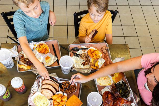 Table of food at Redneck BBQ Lab with mother and two boys