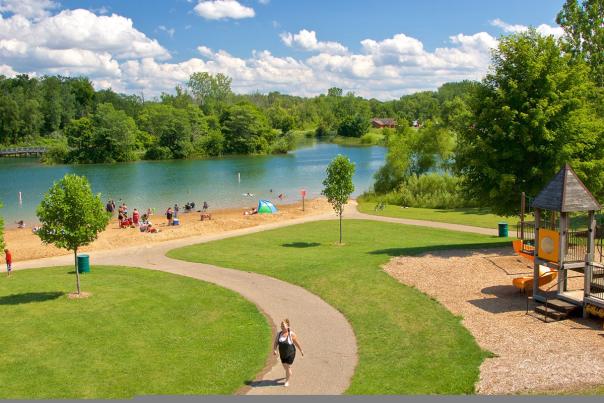 Markin Glen Park features a small playground on a green space that leads to a quiet beach and blue water.