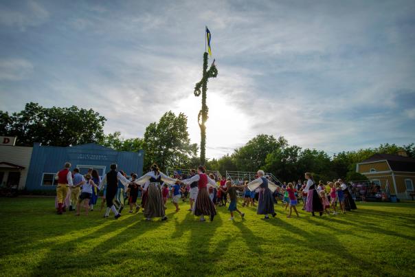 A circle of Swedish Folk Dancers dancing around the Midsummer Pole in Lindsborg.