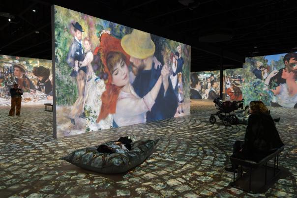 A visitor observes an art wall at the Museum of Art + Light in Manhattan