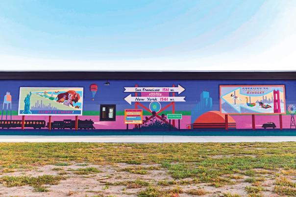 a wide angle of wall mural on the side of a building, it's vibrant colors of pinks, blues and purples.