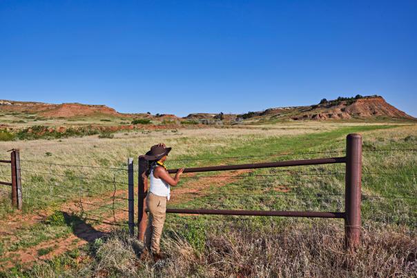 Woman stands by fence at the Gypsum Hills scenic byway